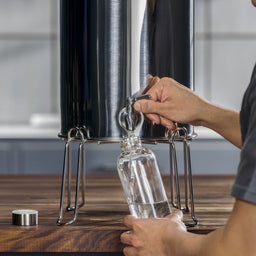 man filling water bottle with water from maxclear gravity spigot