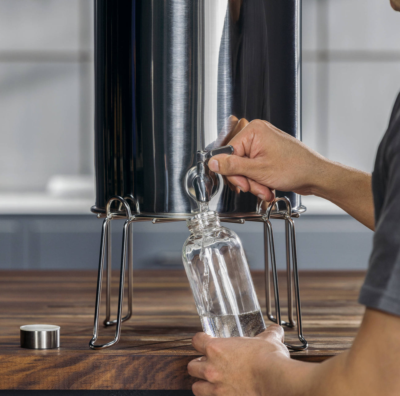 man filling water bottle with water from maxclear gravity spigot