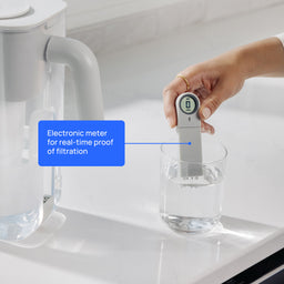 electronic tds meter in glass of filtered water