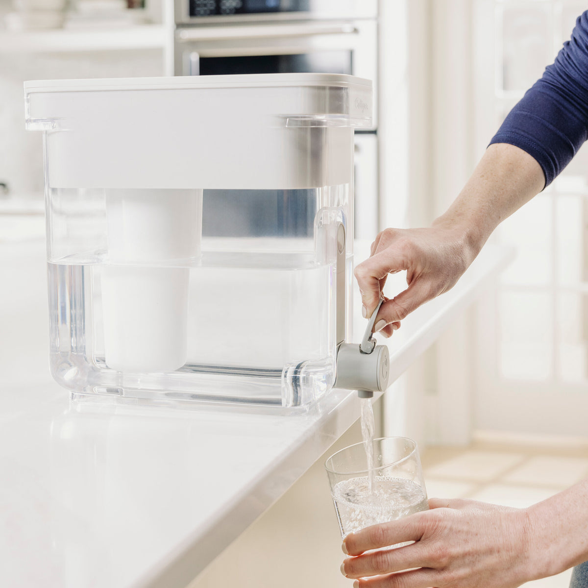 person pouring water from 22 cup zerowater dispenser spigot