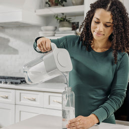 woman pouring water into bottle from 7 cup zerowater pitcher